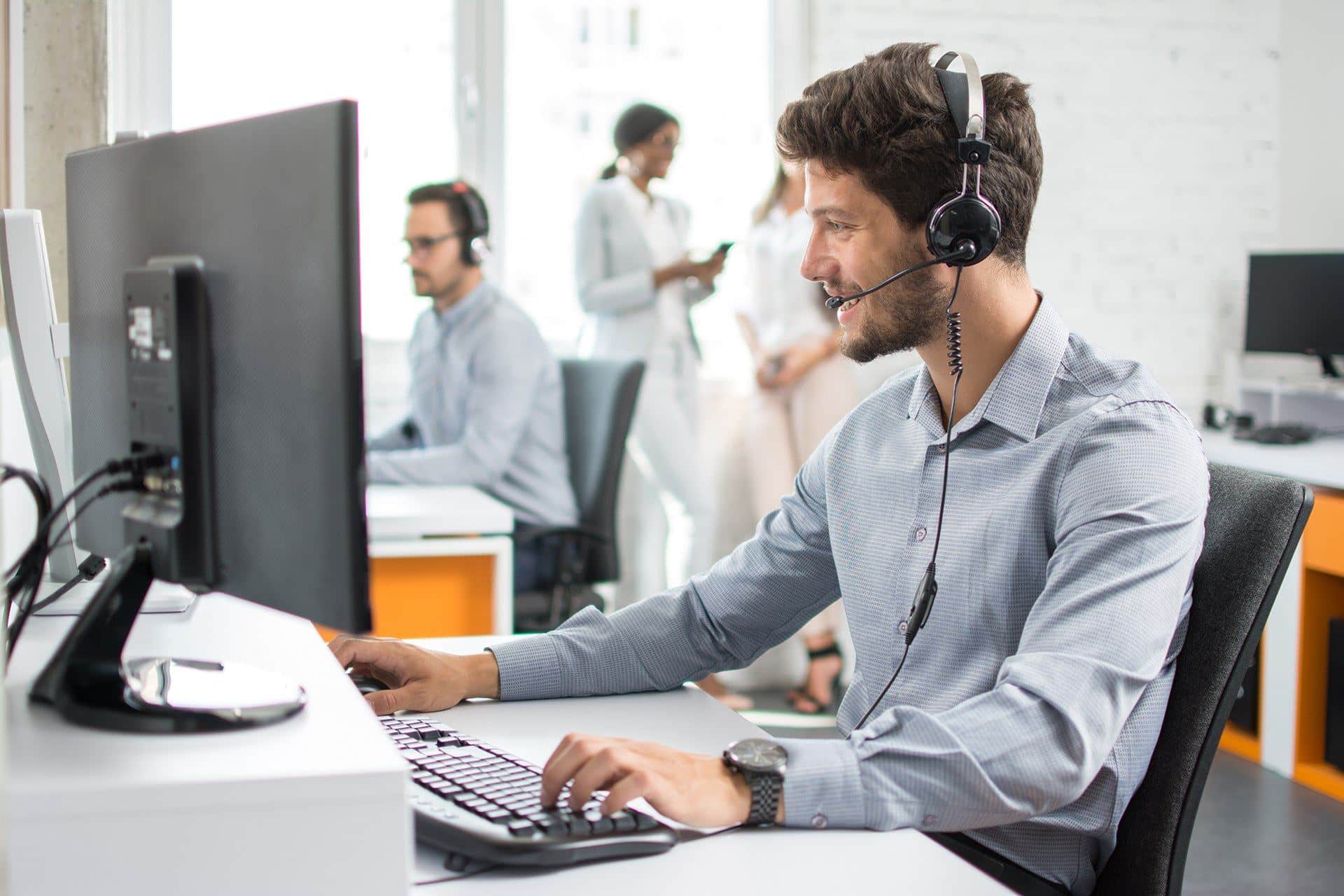 a man sitting at a computer with headphones on